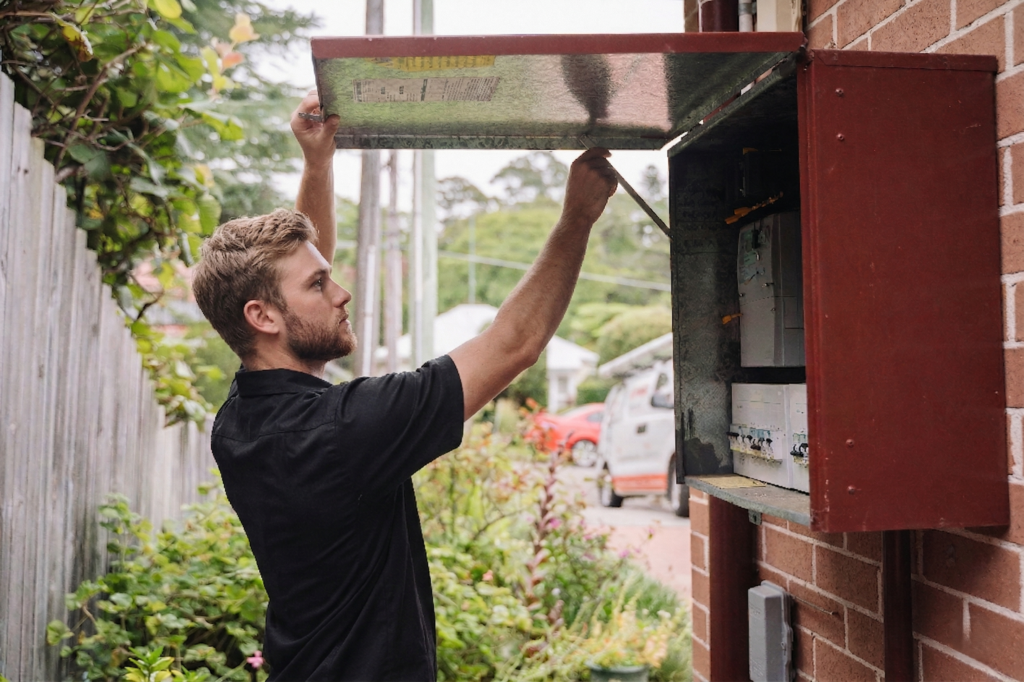 Electrician installing downlights in a Botany home